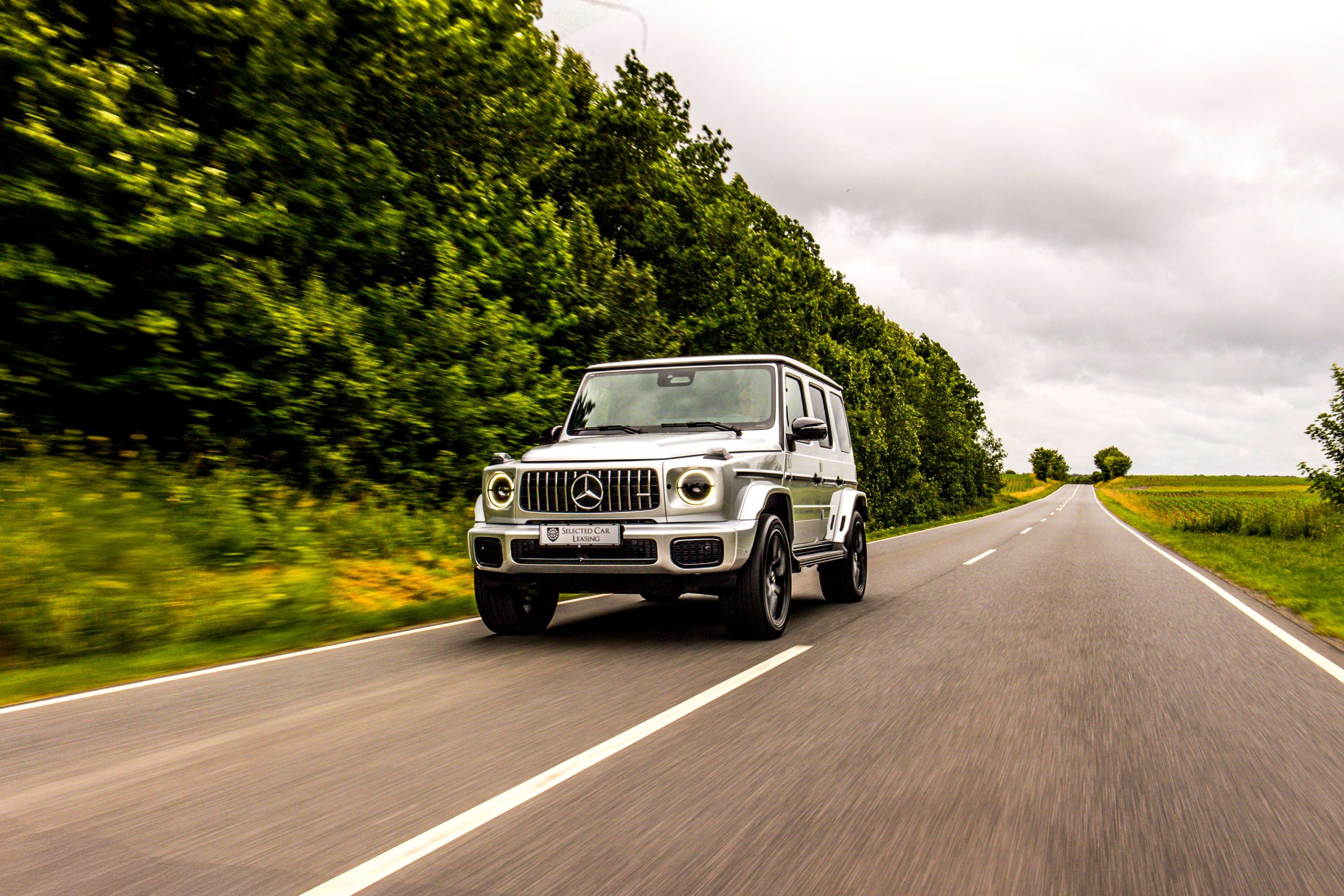 Sølvfarvet Mercedes-Benz G-Klasse på landevej