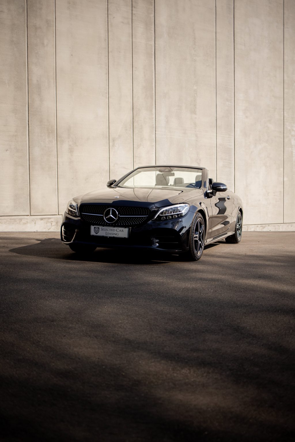 Sort Mercedes-Benz C-Klasse Cabriolet foran betonbygning